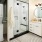 Large well lit bathroom with tile floors a large walking shower and a washer and dryer in the closet 