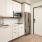 Spacious and well lit kitchen with wood floors and stainless steel appliances. 