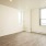 Spacious and well lit living room with wood floors and an open floor plan with access to the kitchen.
